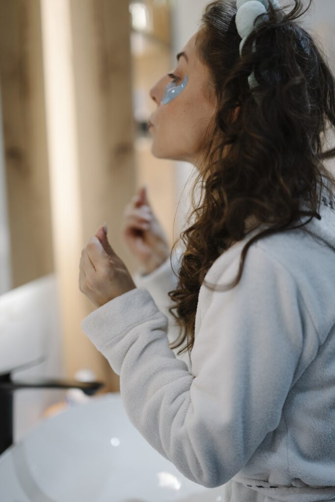 Young woman applying skincare products in a bathroom