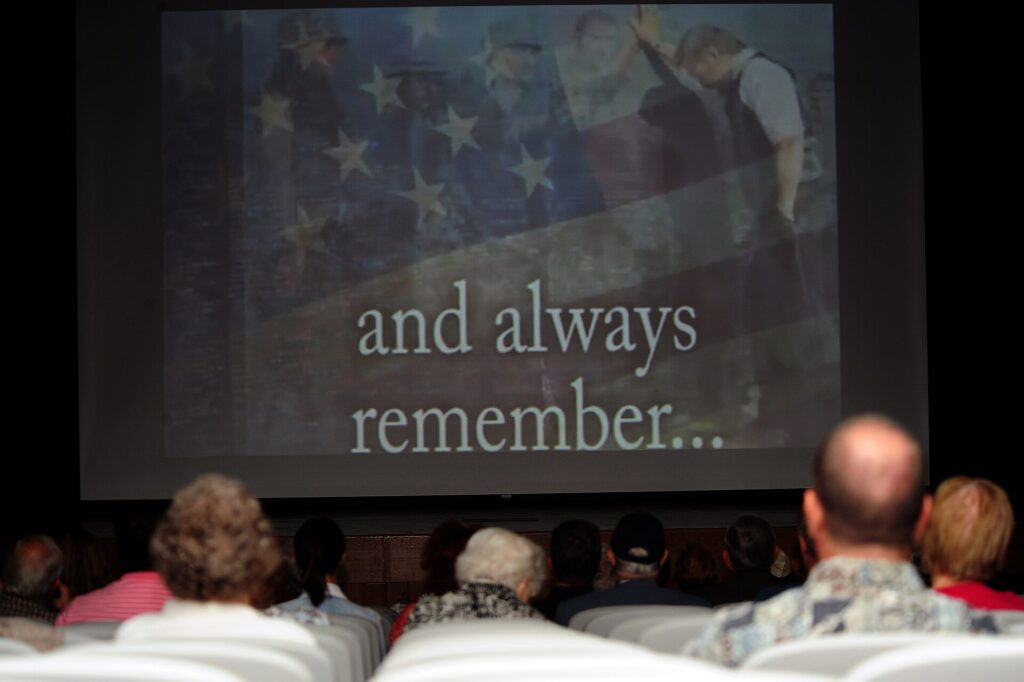 Audience members watch a slideshow presentation during the Wayne County Memorial Day Ceremony at Wayne Community College in Goldsboro, N.C., May 27, 2013 130527-F-YG094-017